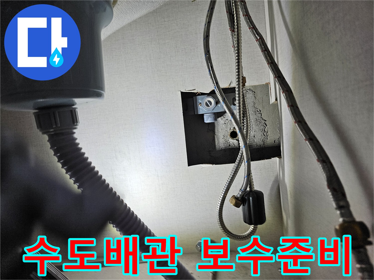 싱크대 하부장 내부의-수도 배관 연결 부위를-점검하고-보수를 준비하는 모습입니다.