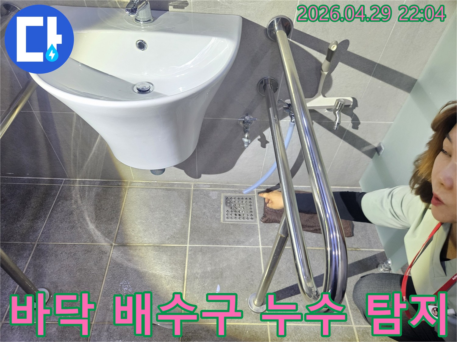 누수 전문 기술자가 화장실 바닥 배수구 주변의-미세한 물샘을-정밀하게 탐지하고 있습니다.
