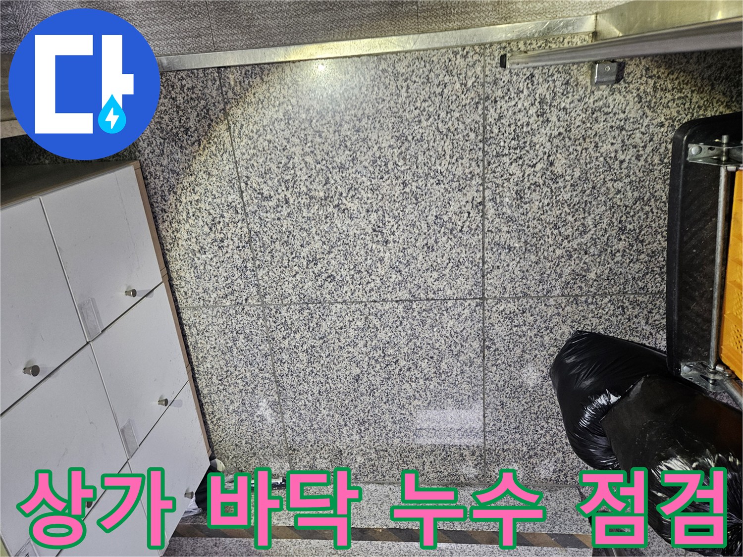 포천 상가 건물에서-바닥 타일의 젖은 부분을 발견하여-누수 전문가가 현장을 면밀히 살피는-초기 진단 단계입니다