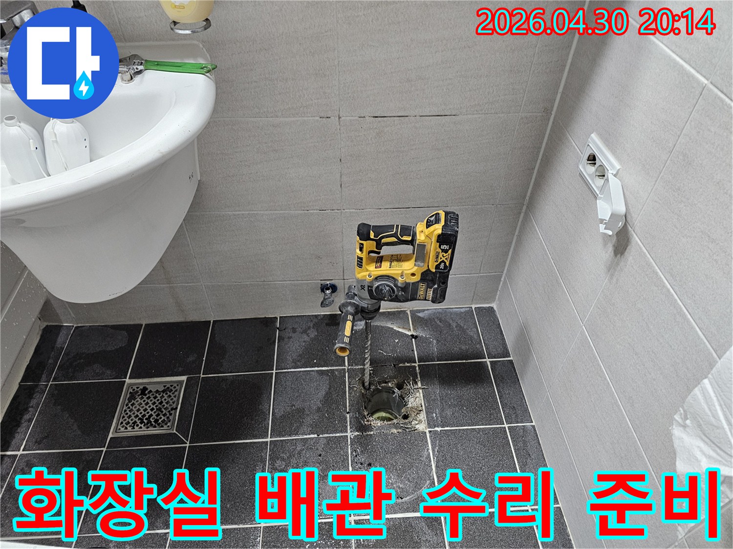 김포 아파트 화장실 바닥 배관 누수 문제를 해결하기 위해-타일을 천공하고 배관 수리 작업을 준비 중입니다