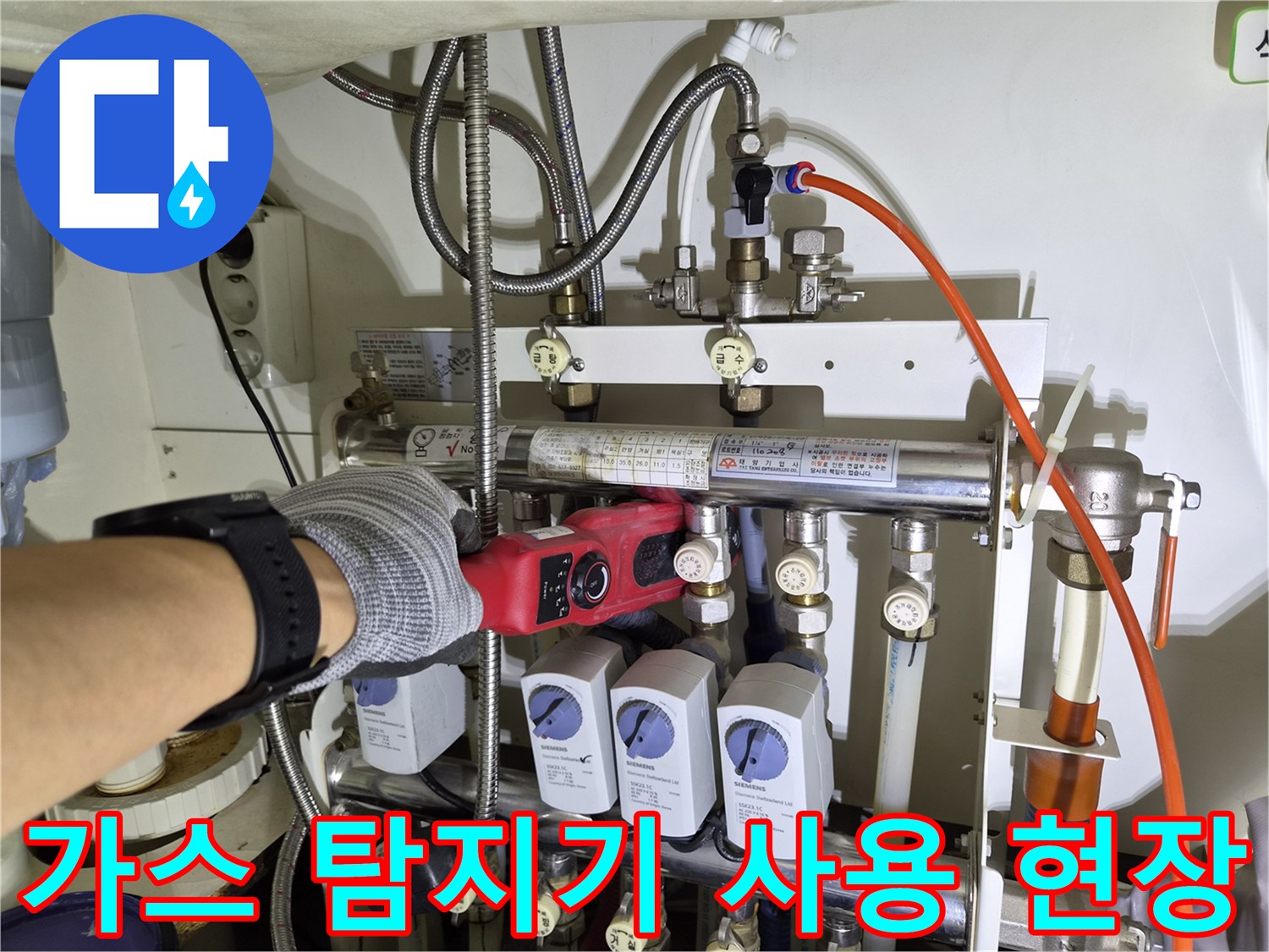 배관 누수 확인을 위해 가스 탐지기를 배관 근처에 대고 있는 모습