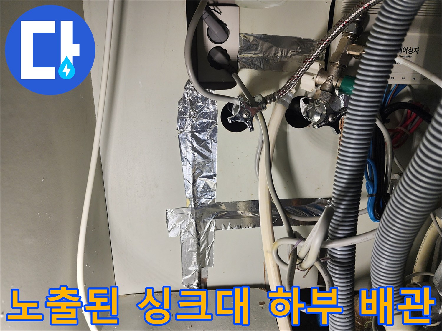 싱크대 뒤쪽 벽면에 연결된 금속 및 플라스틱 배관들