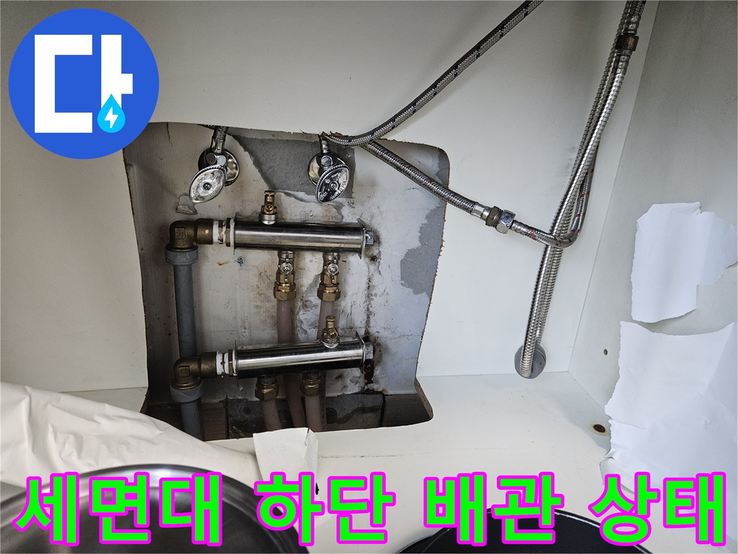 세면대 아래쪽 수전 연결 부위와 배관 노출 모습
