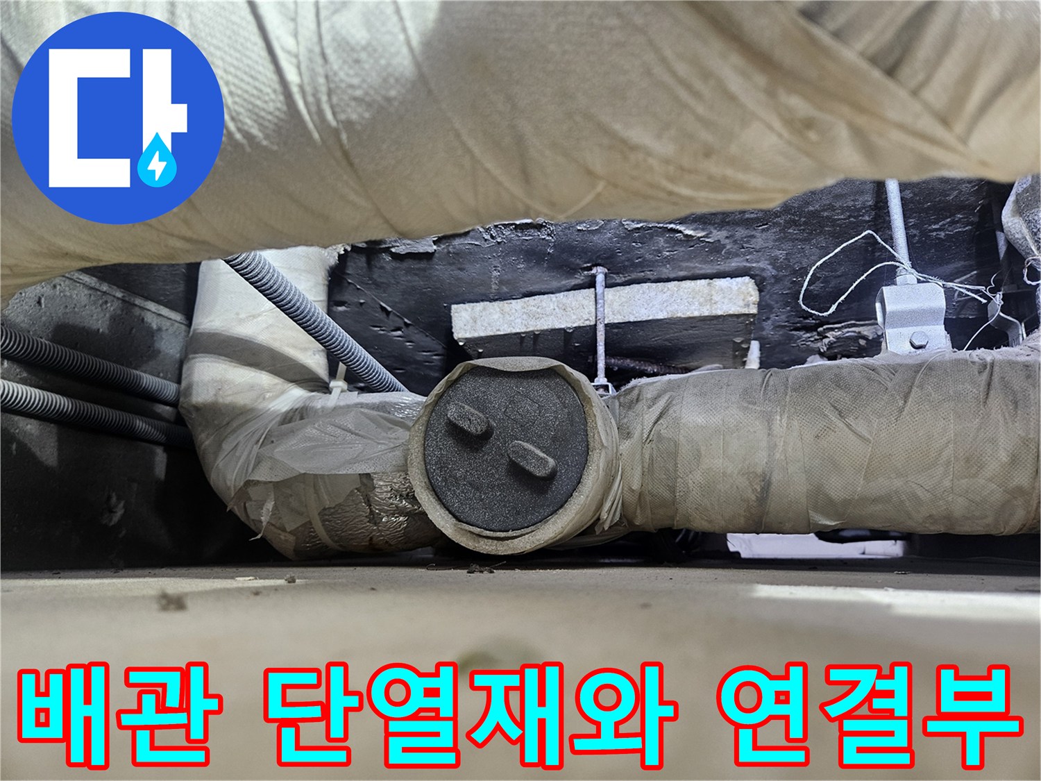 단열재로 감싸진 굵은 배관과 연결 부위의 상태를 보여주는 사진입니다.