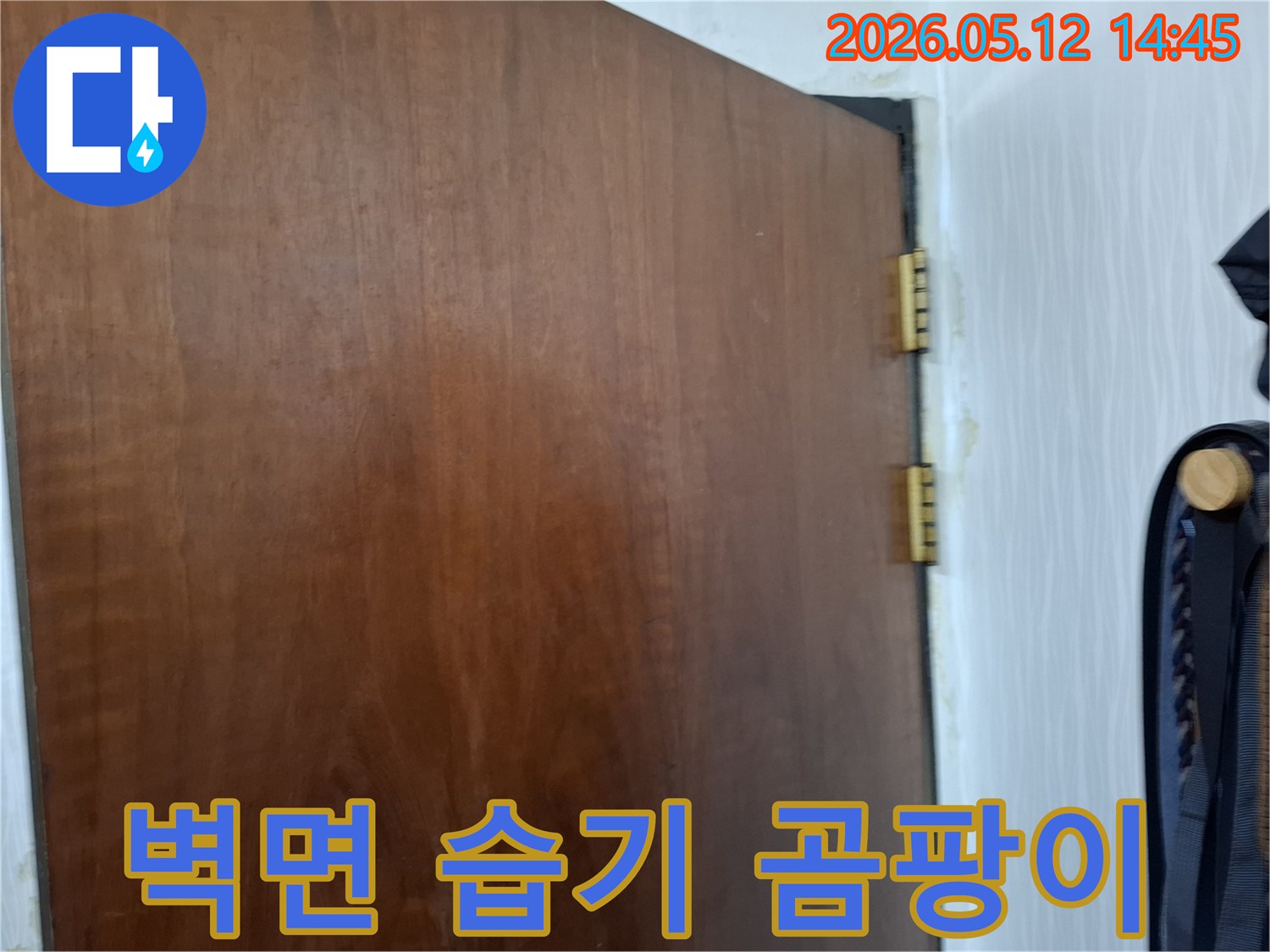 문틀-옆-벽지에-발생한-누수로-인한-습기와-곰팡이-흔적을-자세히-보여주는-사진입니다
