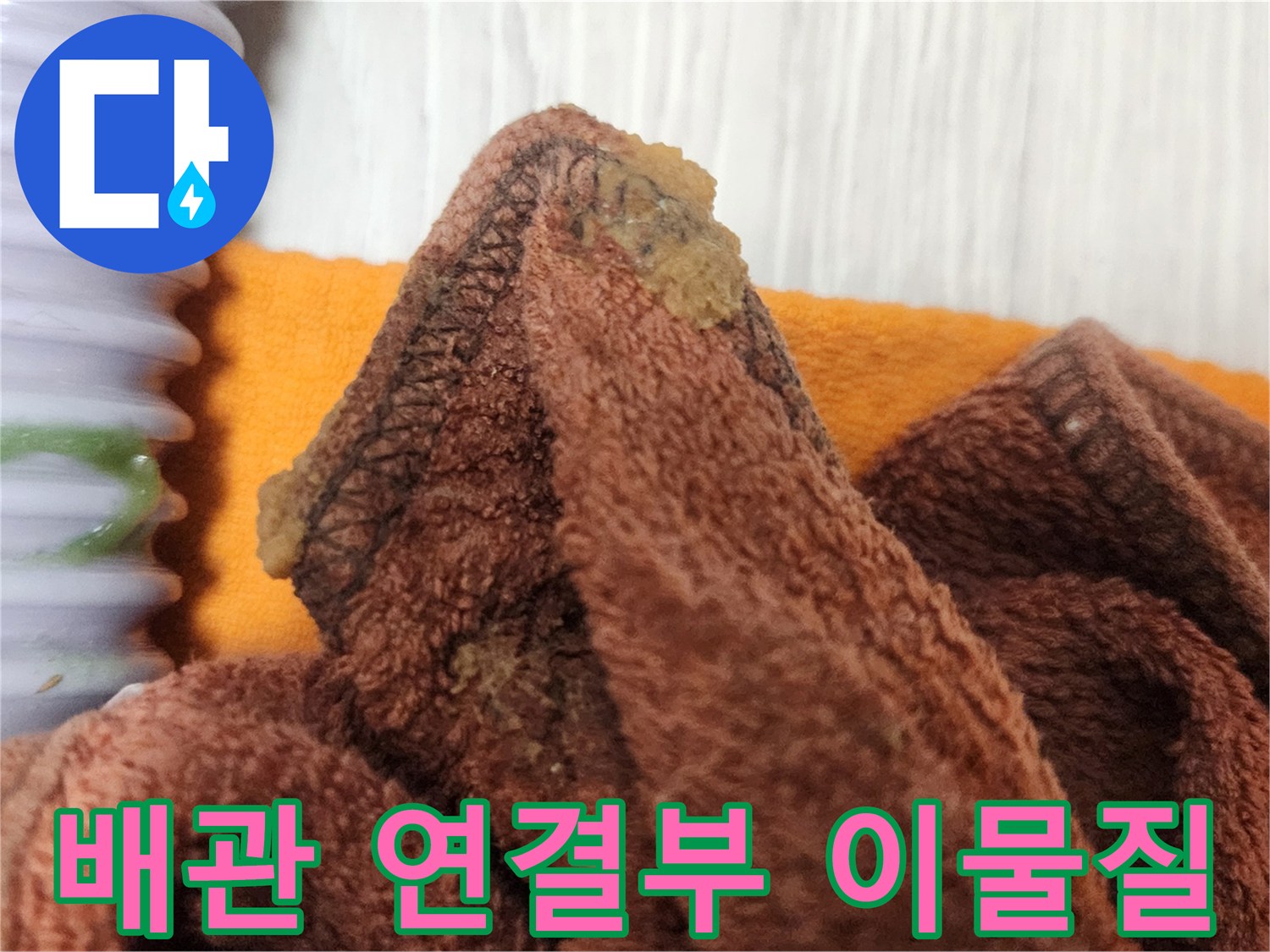 누수 공사 중-배관 연결부에서 발견된 이물질을 제거하는 모습