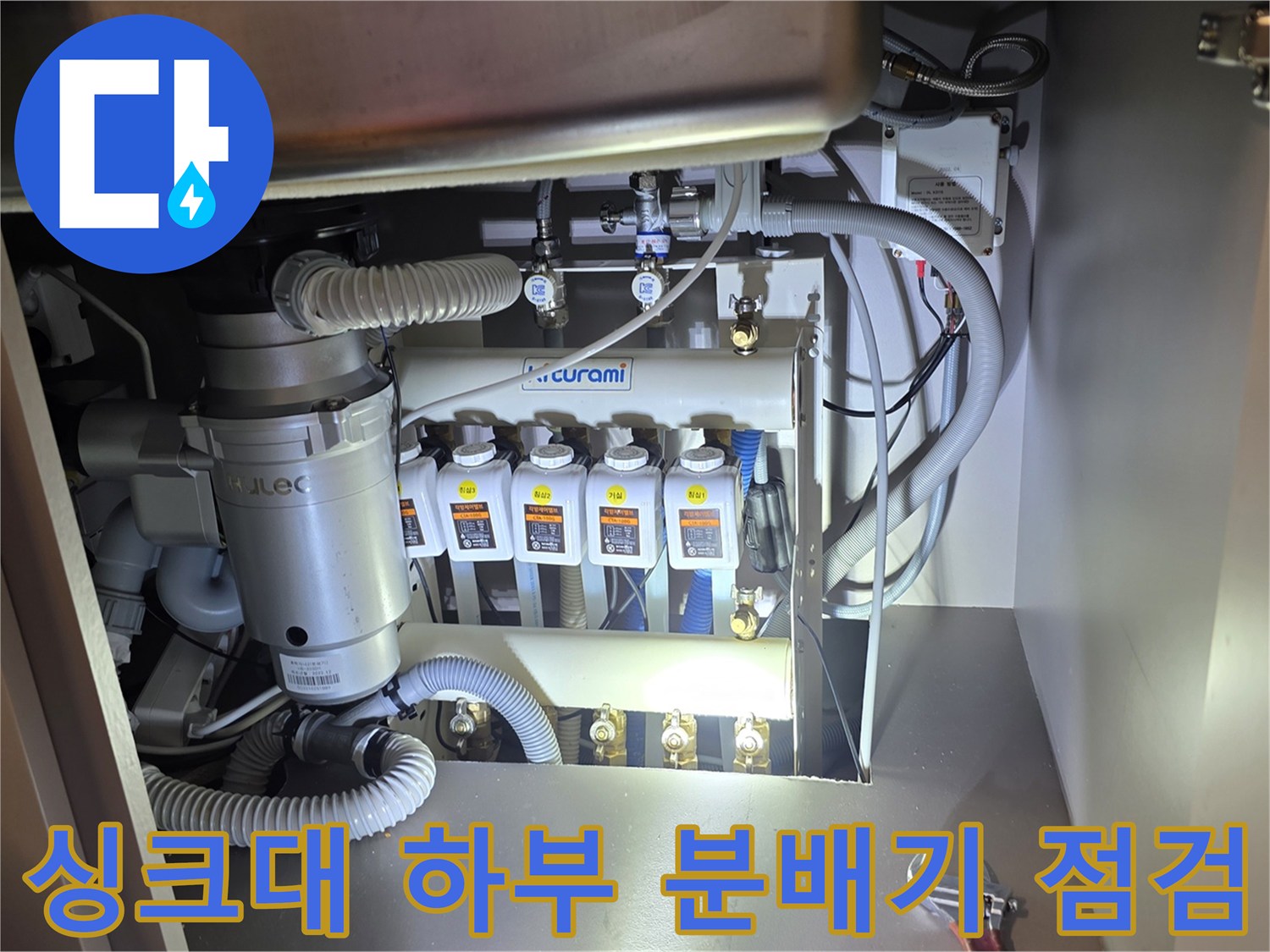 싱크대 하부장 내부의 귀뚜라미 분배기와 연결 배관 구조