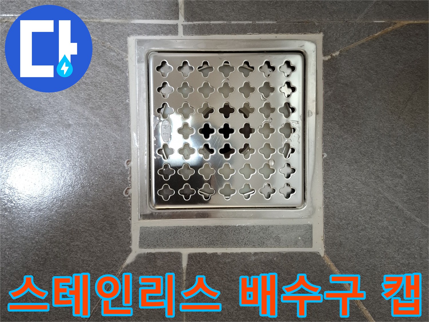 격자 무늬의 스테인리스 소재 배수구 덮개와 주변 타일