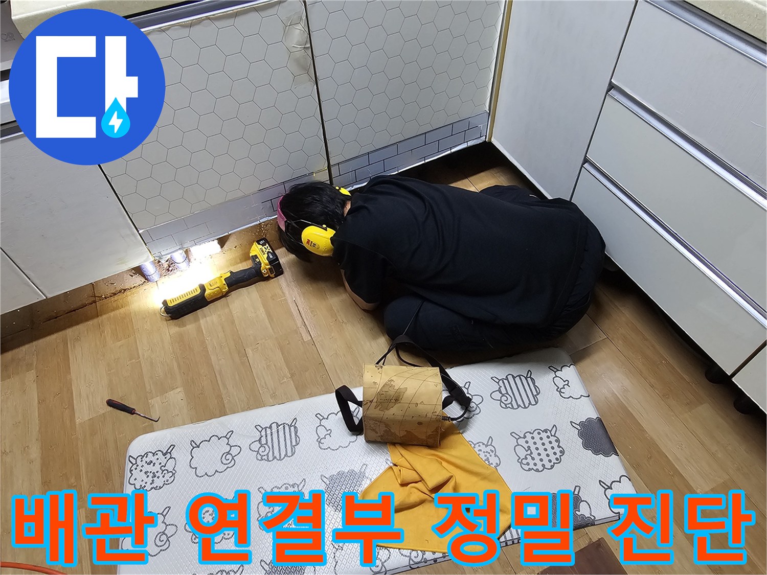 싱크대 밑 배관의 연결 상태와 누수 여부를 확인하는 작업 장면