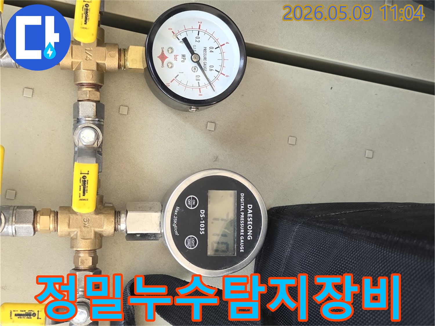 배관 누수 여부를 확인하기 위해 정밀 압력 게이지와 밸브가 연결된 배관 시스템의 근접 사진