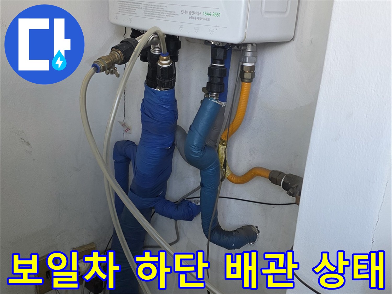 보일러 아래쪽의 보온재로 감싸진 수도 배관 및 연결 부위