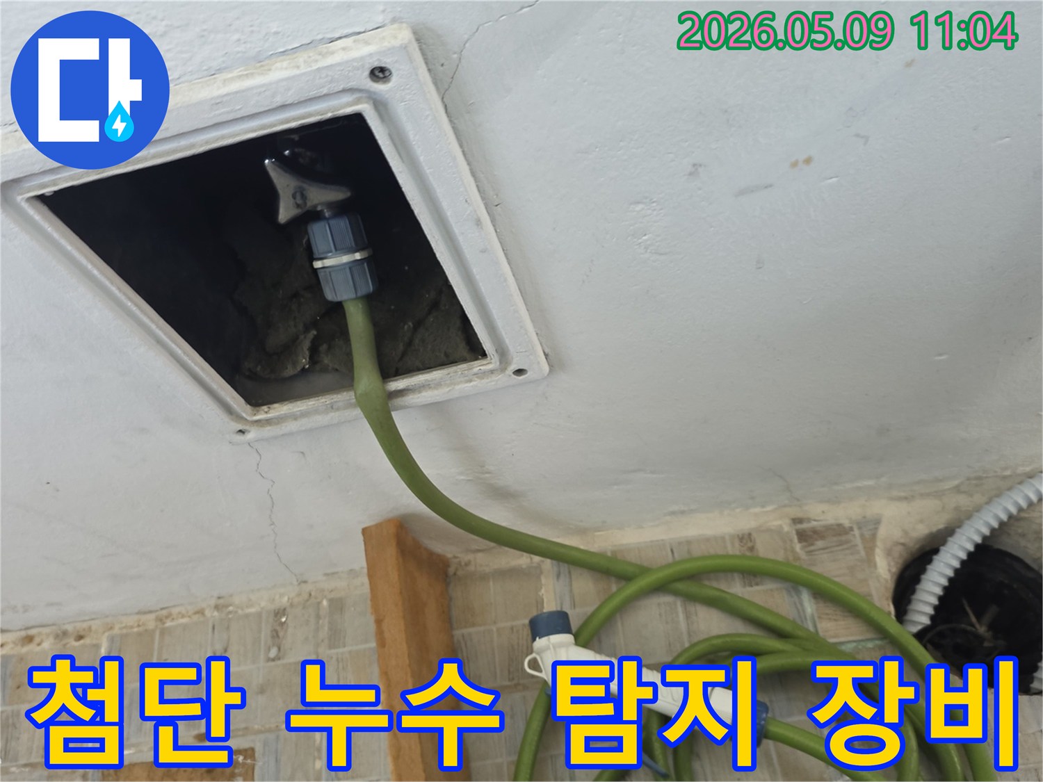 천장 점검구를 통해 첨단 누수 탐지 장비의 호스를 삽입하여 내부를 정밀하게 검사하는 모습