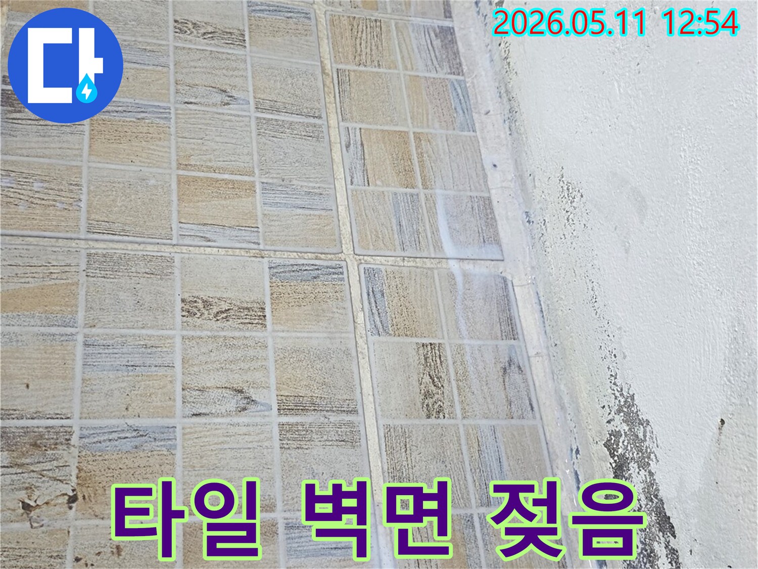 타일-벽면과-천장-경계에-물기가-스며들어-젖어있는-누수-현장을-보여주는-이미지