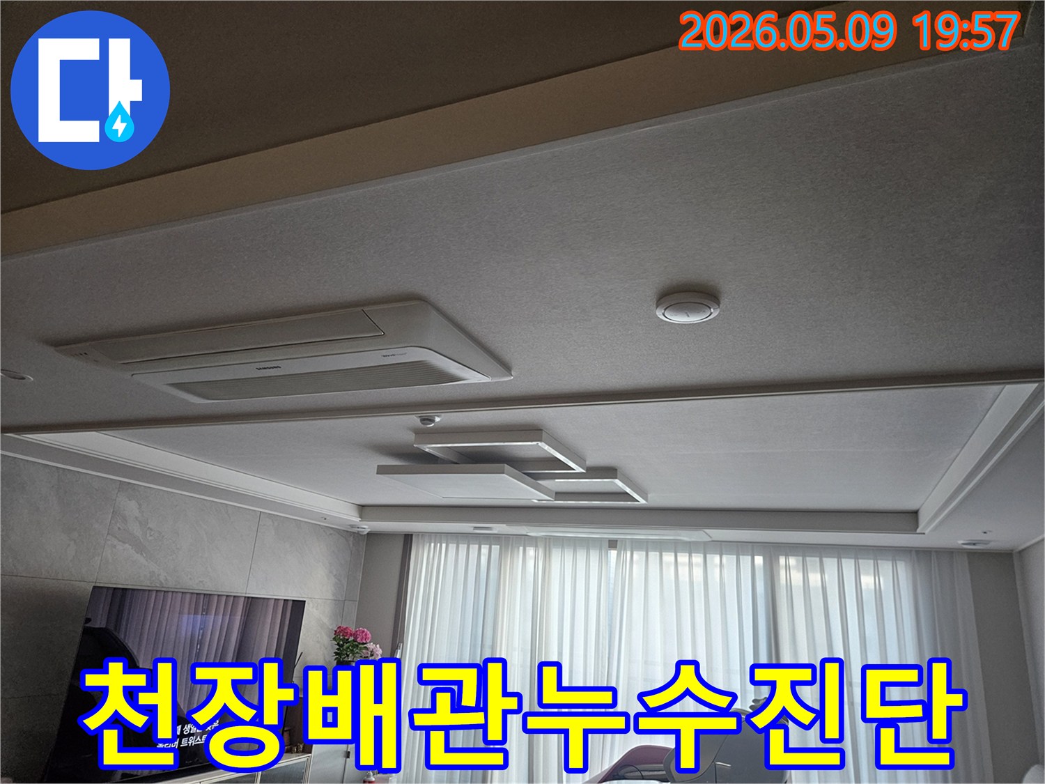 고객님 댁 거실 천장의 모습으로-배관 누수가 의심되는 상황에서-초기 점검을 진행하는 장면을 담고 있습니다.
