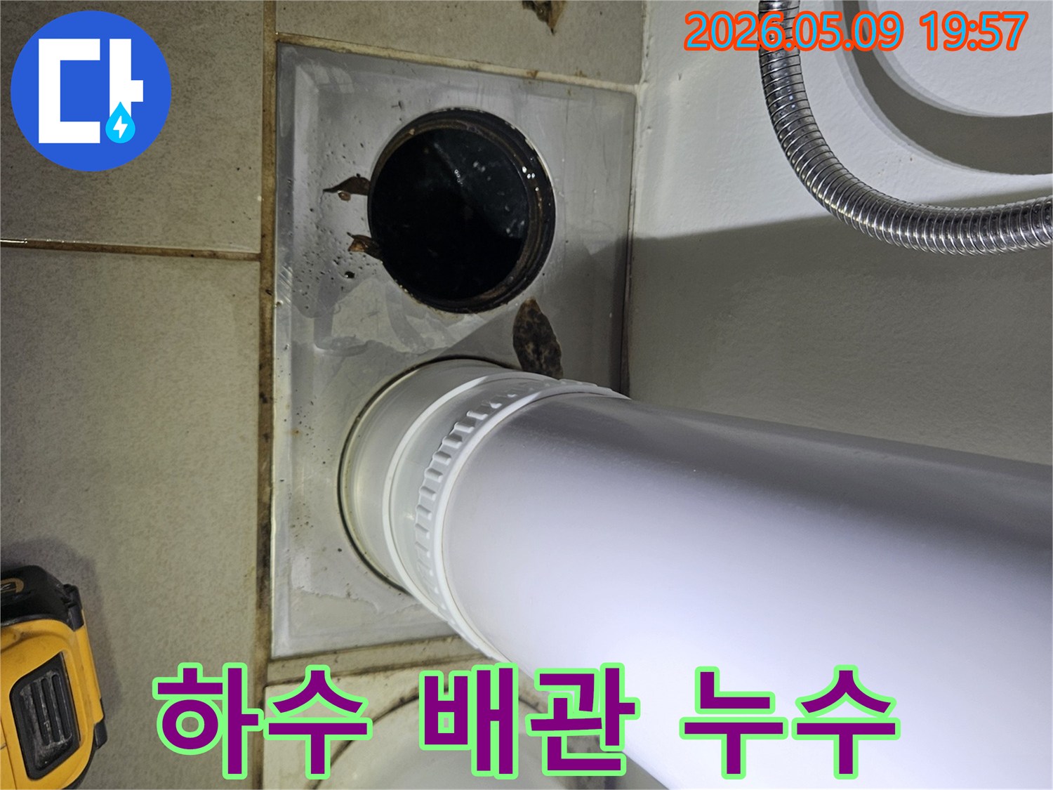 이 사진은 욕실 바닥의 하수 배관 주변에서 발생한 물 고임과 오염 현장을 보여주며-긴급한 조치가 필요함을 시사합니다.