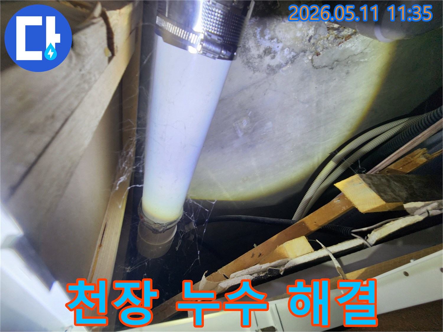 천장 내부의 배관에서-발견된 물기 자국과-주변 습기 흔적을-면밀히 조사하는 장면입니다.