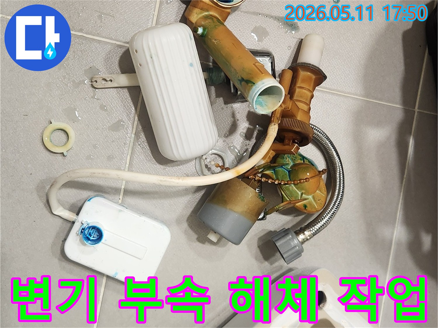 안방 변기에서 발생한 물샘 문제를 해결하기 위해-오래된 변기 부속들이 해체되어 바닥에 놓여 있는 모습입니다-새 부품으로 교체하여 변기를 수리할 예정입니다