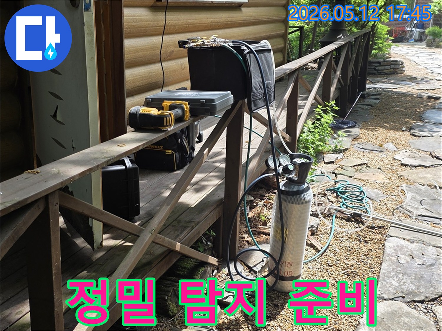 빌라 외벽 옆-누수 탐지용 가스통과-장비들이 놓여있는 장면