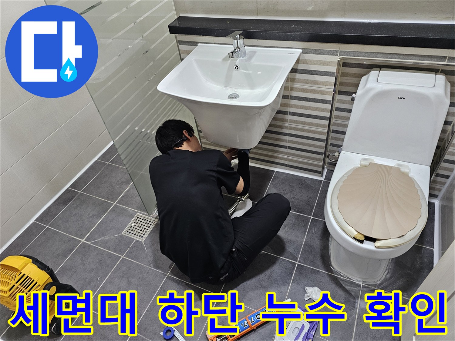 세면대-아래쪽-배관-연결부의-물샘-현상을-조사하는-모습