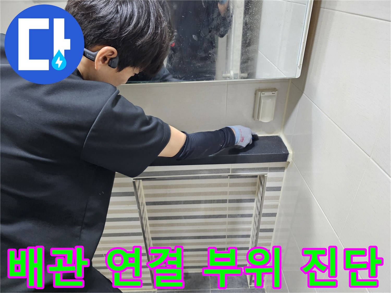 세면대 아래쪽 배관과 트랩의 노후도를 확인하기 위해 작업자가 손을 대고 있습니다.