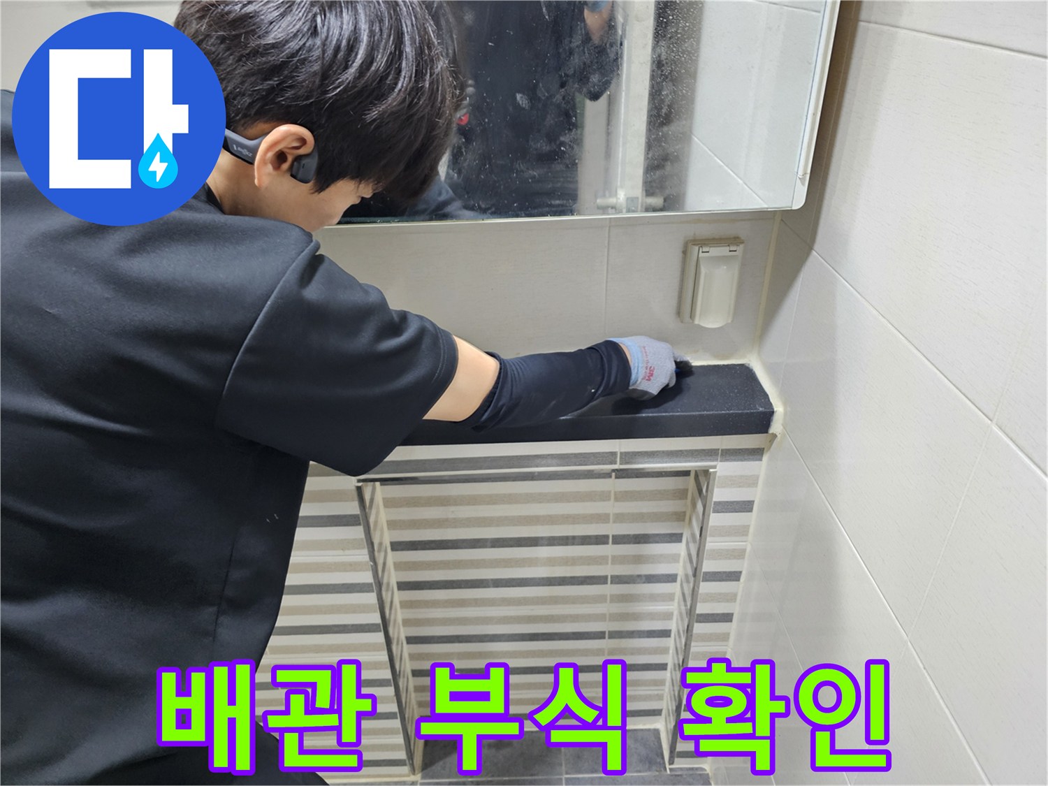 장갑을 낀 작업자가 세면대 하단 배관의 연결 상태를 점검 중