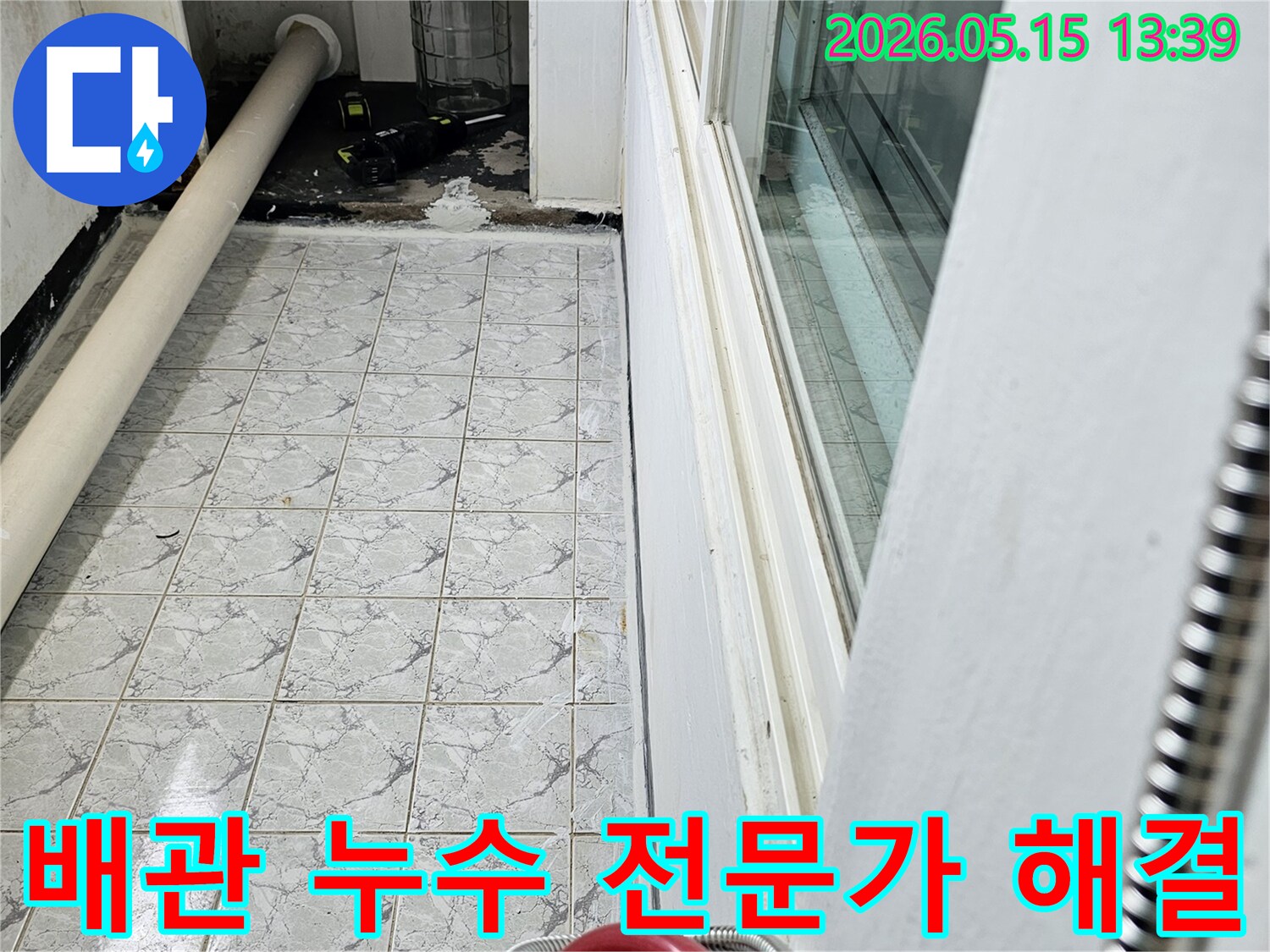 이 사진은 의정부 신곡동 아파트의 배관 누수 현장을 전문가가 해결하는 과정을 포착한 것입니다-배관과 주변 타일의 물자국이 선명합니다