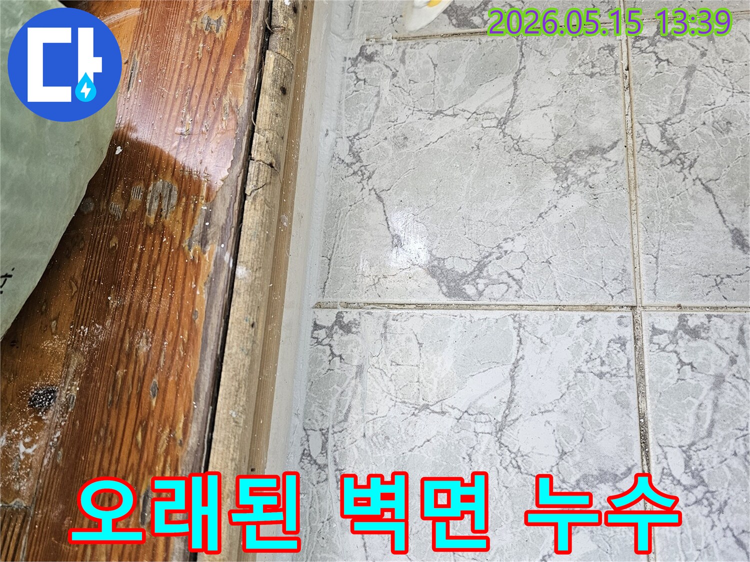 이 이미지는-의정부 신곡동의 오래된 아파트에서 발생한-벽면 누수로 인해-타일 줄눈과 목재 마감재가 부식된 모습을 보여줍니다