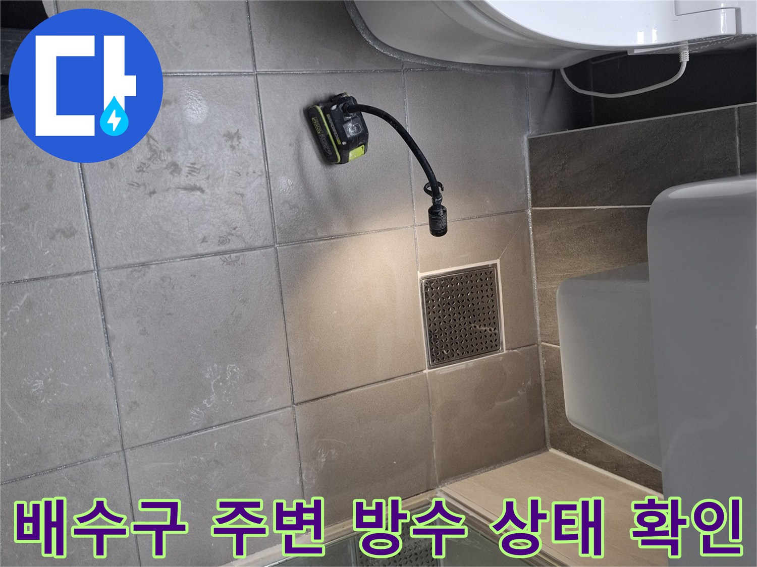 유가 주변 타일 틈새와 배수구 내부를 정밀하게 관찰하는 장면