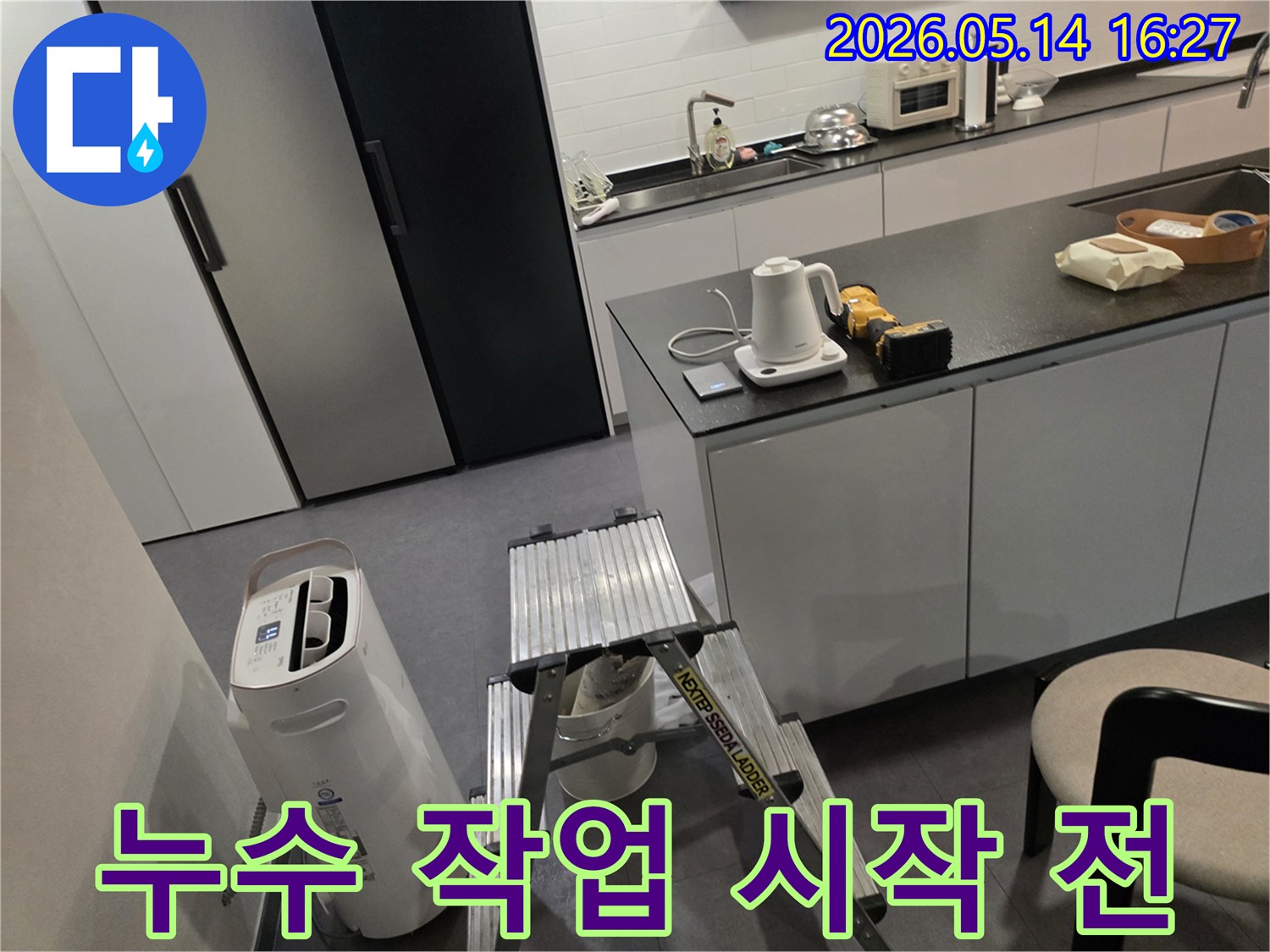 누수 탐지 전문가가-고객님의 주방에서-작업 전-장비 점검과-환경 확인을 하고 있습니다.