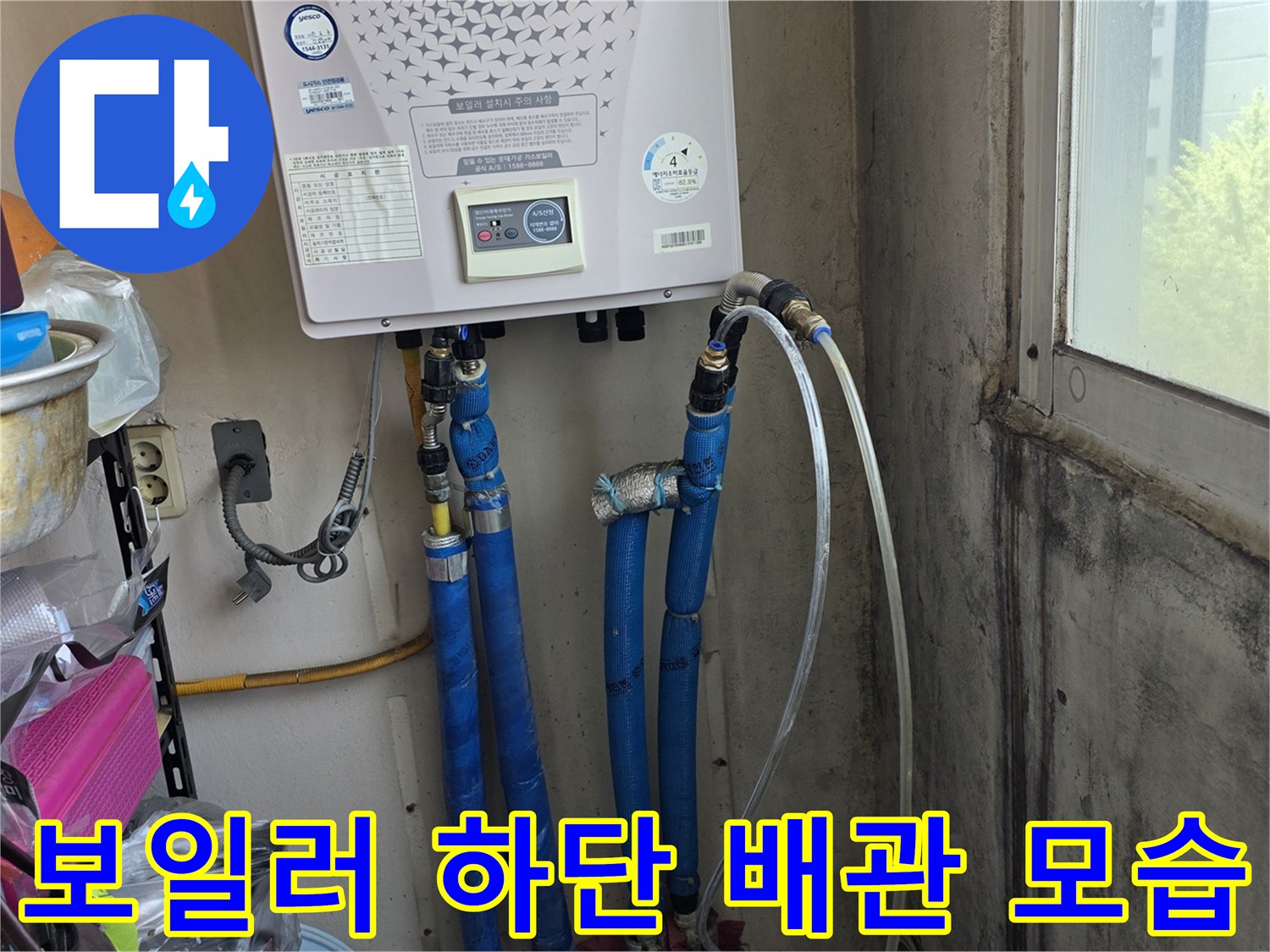 보일러 아래쪽 파란색 주름관과 연결 부속들의 근접 촬영