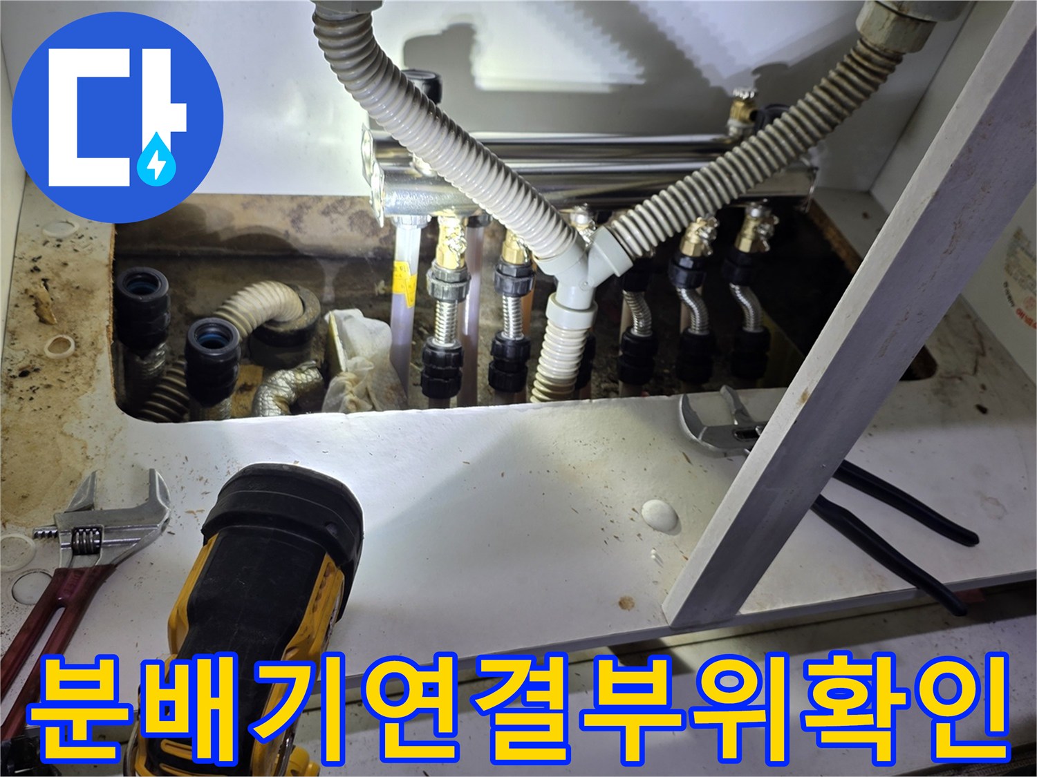 싱크대 하단 분배기의 주름관 연결 부위를 상세히 촬영한 이미지입니다.