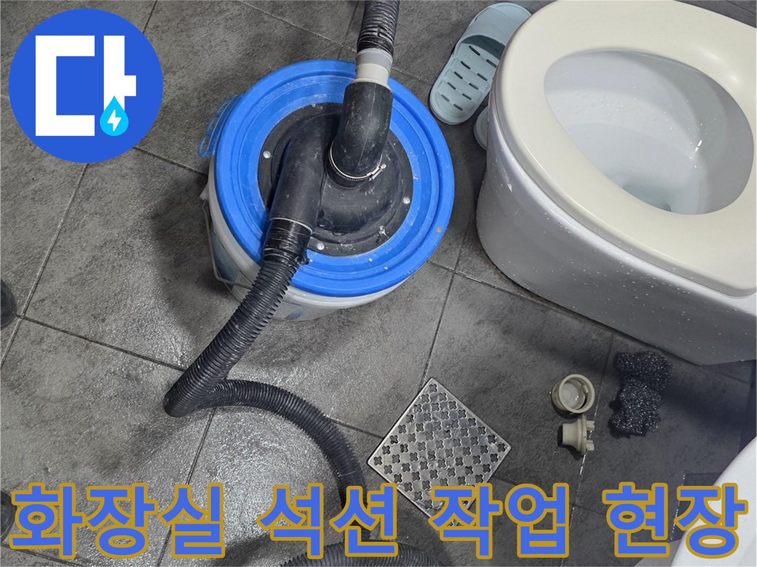 화장실 바닥 배수구 주변에서 석션 장비를 사용하여 이물질을 흡입하는 모습