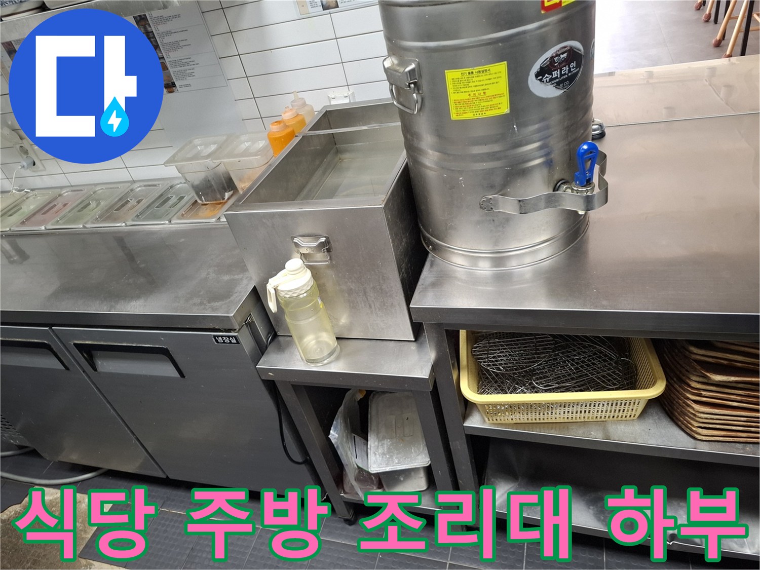 조리 기구와 식기가 정리된 주방 내부의 스테인리스 선반 아래쪽