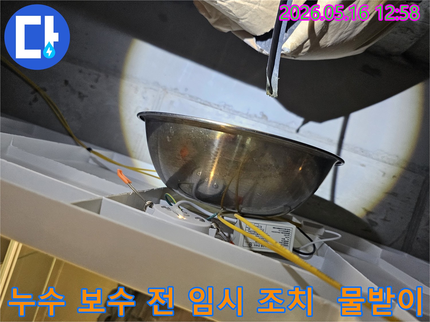누수 보수 작업을 시작하기 전-천장에서 물이 떨어지는 것을-스테인리스 볼로-받아내며-주변의 전기 배선과-조명 장치를-보호하는 모습