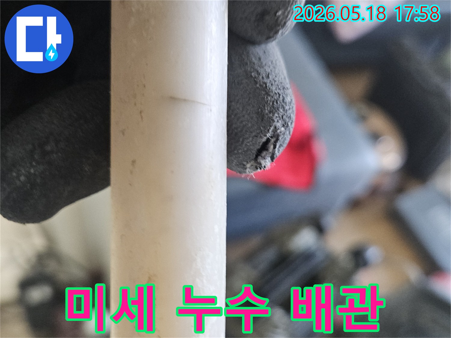 작업용-장갑을-낀-손으로-미세한-누수-배관의-균열을-가리키는-현장-사진
