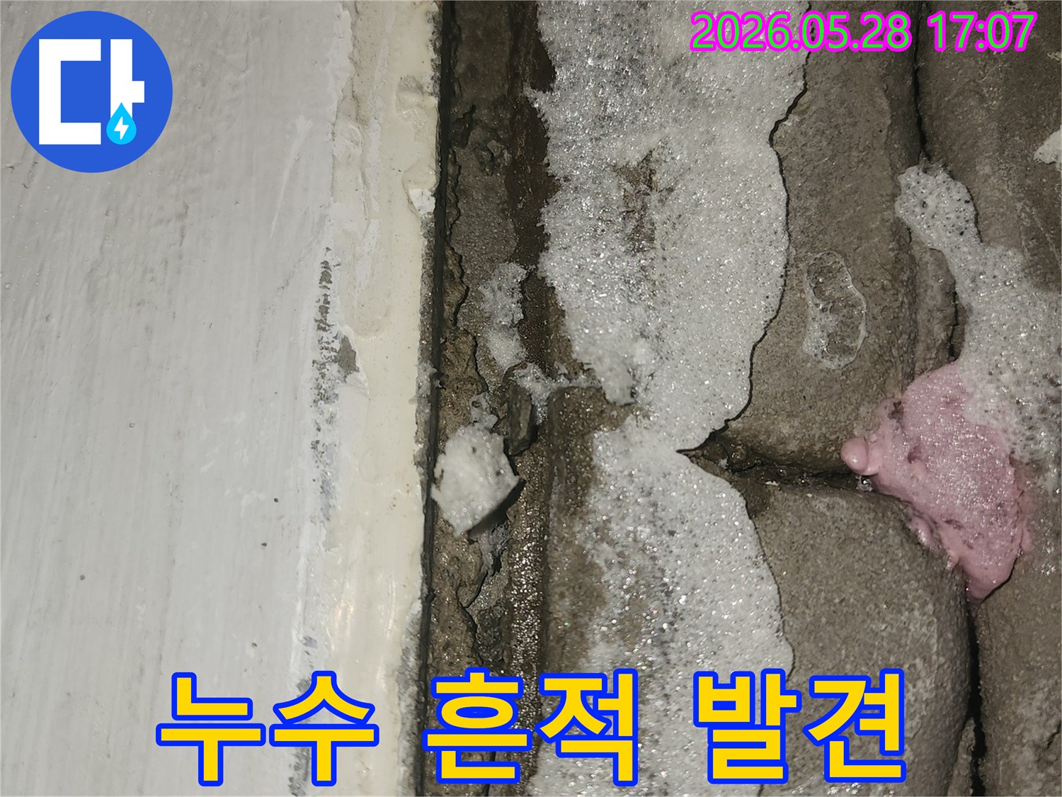 문틈-사이로-물이-새어-나와-벽면이-손상된-세탁실-누수-현장의-클로즈업-사진입니다