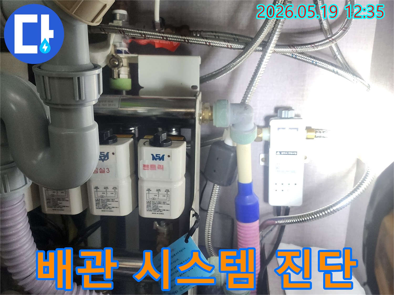 누수 원인을-정확하게-찾아내기 위해-복잡하게 연결된-배관과-정수 장비를-전문가가-면밀히-점검하는-모습입니다.