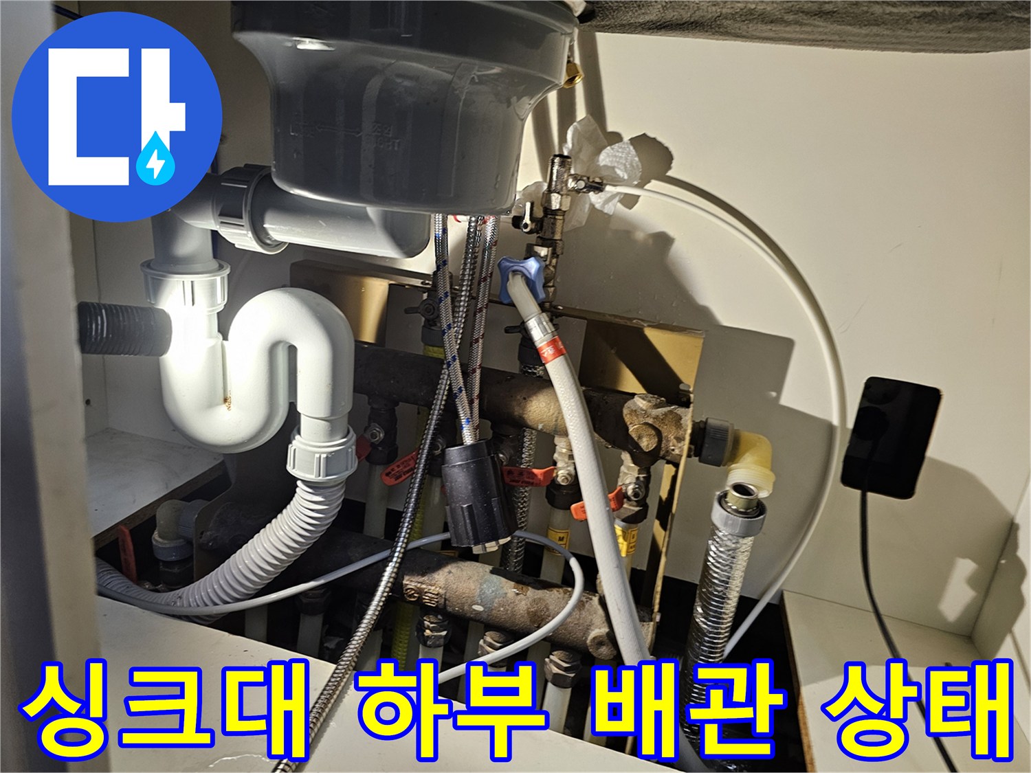 오산 주방 싱크대 아래 복잡하게 연결된 배수 및 급수 배관 모습