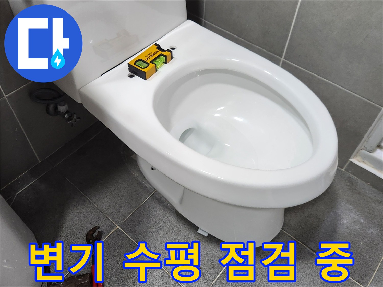 새로운 변기를 설치하기 전-수평계를 사용하여 변기의 수평을-정확하게 점검하는-전문가의 작업 현장입니다