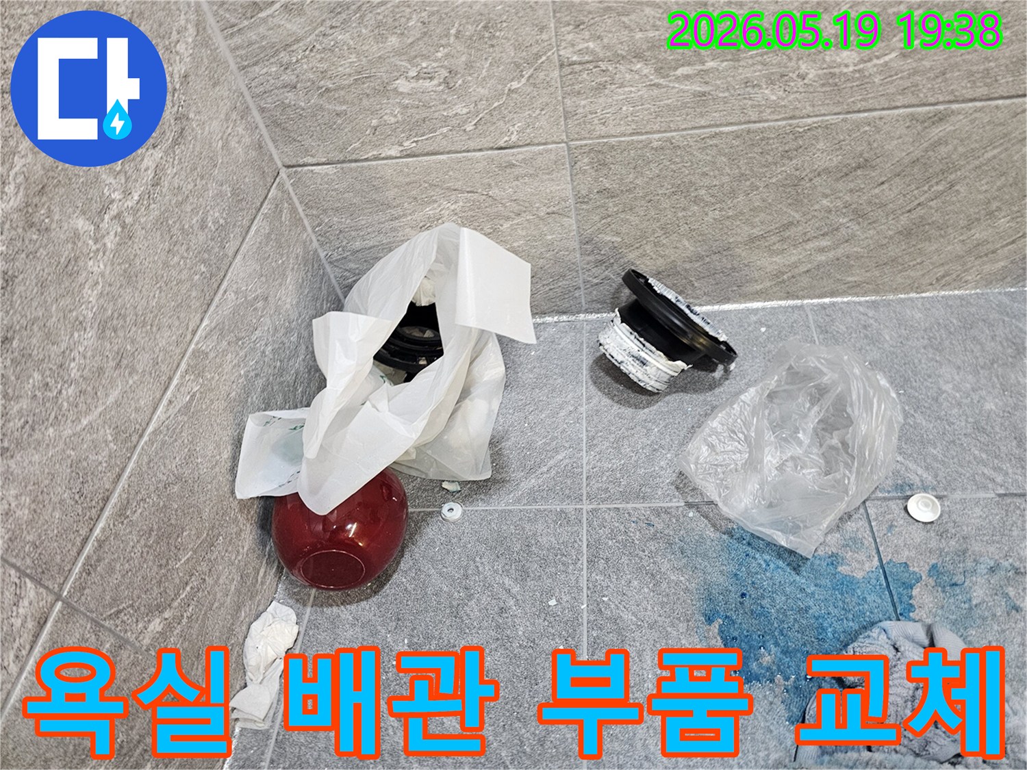 누수 탐지 작업 중-욕실 바닥에서 발견된-오래된 배관 부품과-염료 흔적-교체 작업 대기