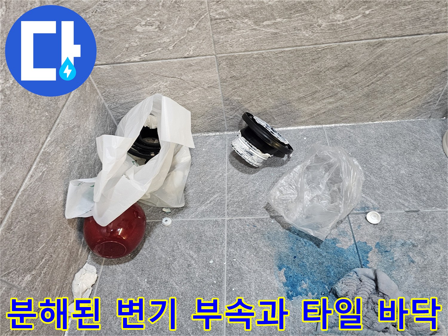 변기 탈거 후 노출된 배관 연결 부품과 습기가 남은 타일