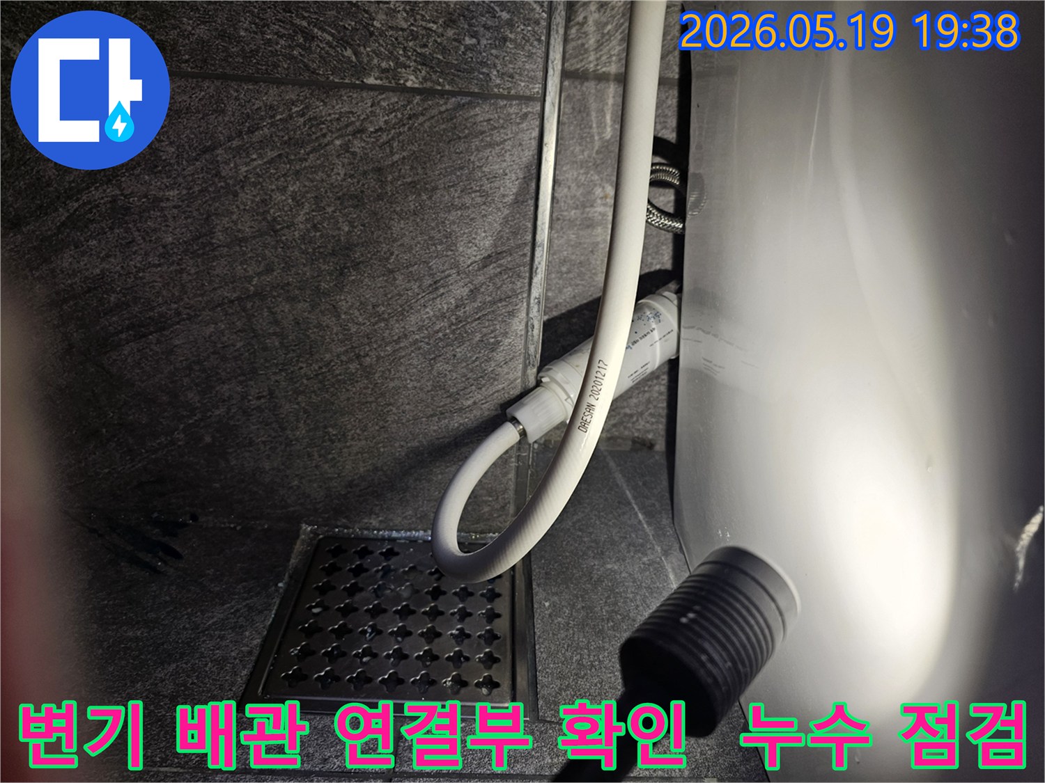 이 이미지는-수지구 풍산아파트 화장실에서-변기 배관 연결부의 누수 여부를-플래시로 비추어-정밀하게 확인하는 현장 사진입니다.