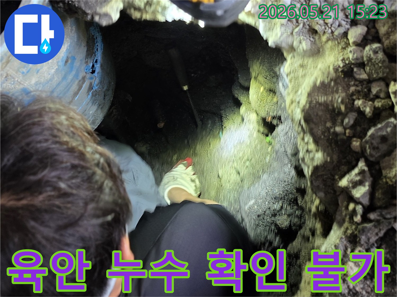 누수 전문 엔지니어가-어두운 굴착 현장에서-손전등을 비추며-육안으로 확인하기 어려운-배관의 미세 누수 지점을-정밀하게 탐지하고 있습니다.