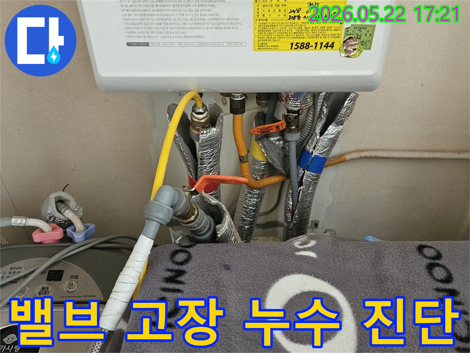 이 이미지는 보일러 주변의 밸브와-배관 연결 부위를 보여주며-밸브 고장으로 인한 누수 진단 현장입니다.