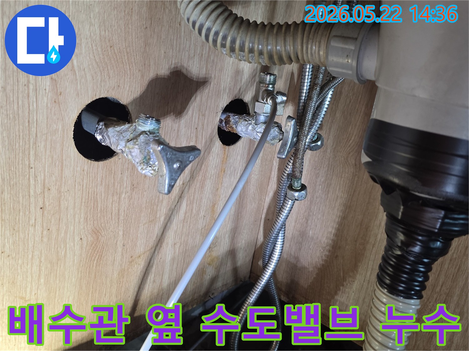 싱크대 하부의 배수관 옆에 위치한 수도 밸브에서 물이 새어 나오는 현장입니다