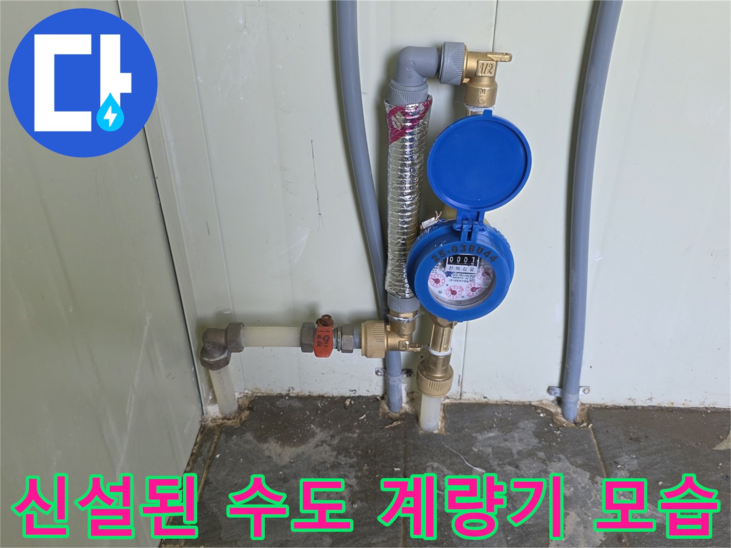 벽면에 고정된 수도 계량기와 연결 배관의 상세 모습