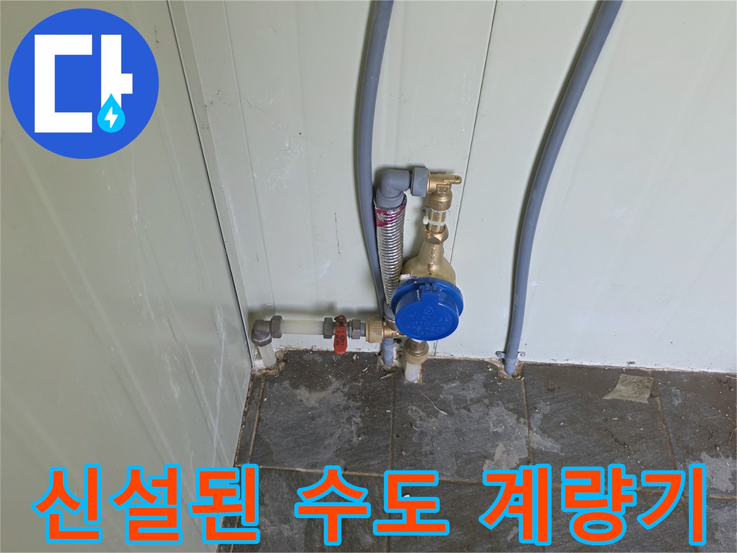 화장실 벽면에 새로 설치된 파란색 캡의 수도 계량기 모습
