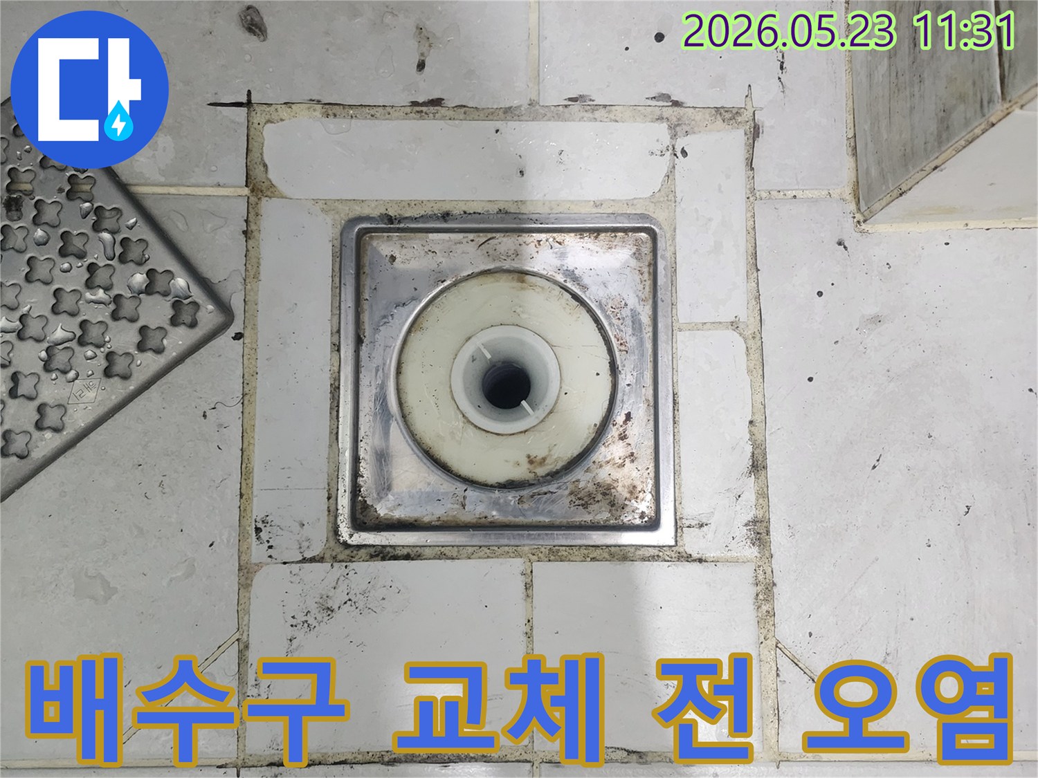욕실 배수구 교체-전-주변의-오염된-타일과-줄눈-상태를-보여주는-사진입니다
