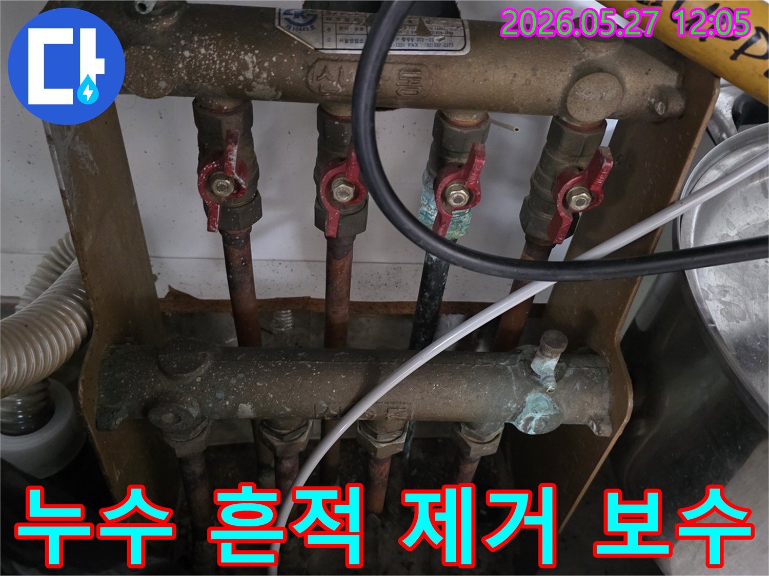 오래된 아파트의 보일러 분배기에서-발견된 누수 흔적을 제거하고-배관 및 밸브를 보수하는 작업을-전문가가 진행하고 있습니다