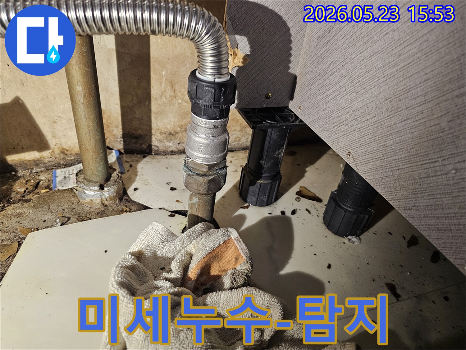싱크대 하부 배관에서 물이 새어-바닥에 젖은 수건이 놓인-미세 누수 현장 사진